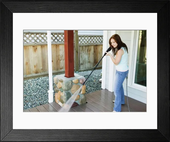 Framed Print : Side profile of a young woman cleaning the porch of her house Framed Print : Side profile of a young woman cleaning the porch of her house