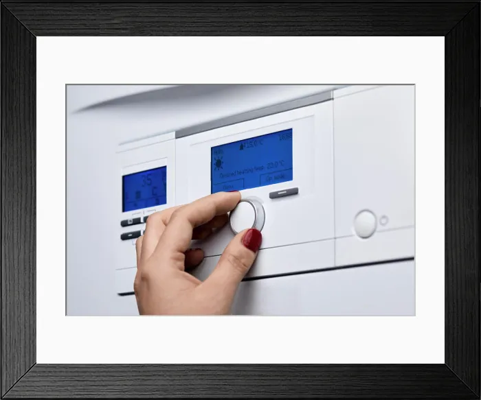 Framed Print : Cropped hand of woman adjusting knob on heating boiler's control panel Framed Print : Cropped hand of woman adjusting knob on heating boiler's control panel
