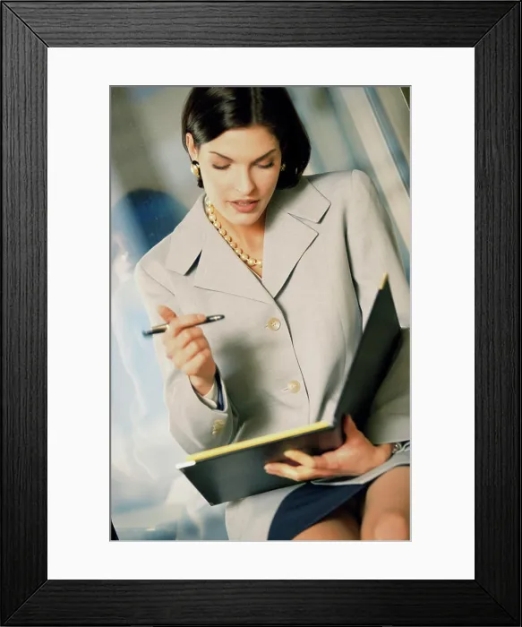 Framed Print : Businesswoman holding a file and a pen Framed Print : Businesswoman holding a file and a pen