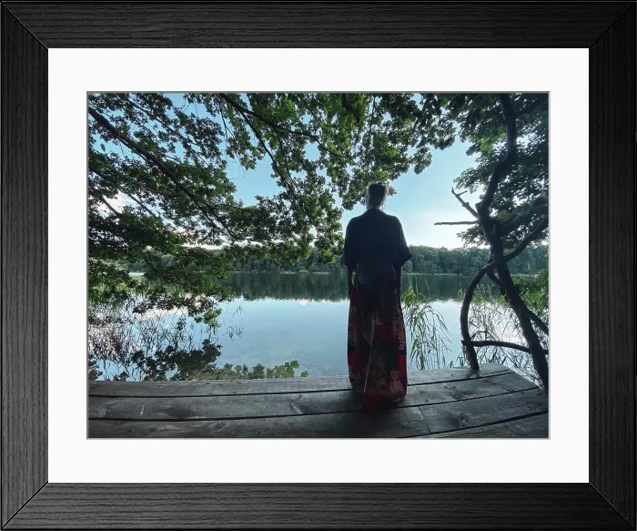 Framed Print : woman in skirt looks out from wooden platform over green natural lake Framed Print : woman in skirt looks out from wooden platform over green natural lake