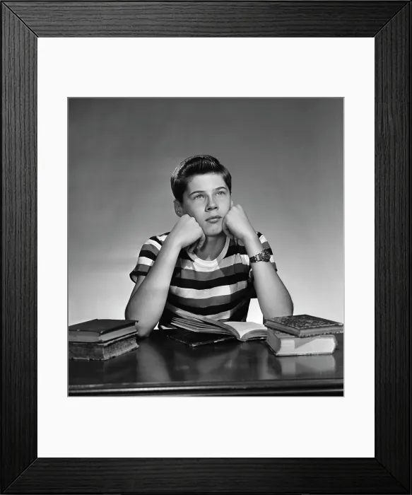 Framed Print : teenage boy sitting wit books open and looking away Framed Print : teenage boy sitting wit books open and looking away