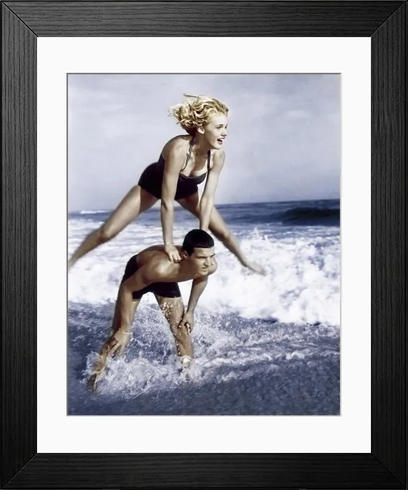 Framed Print : Young couple playing leapfrog in surf