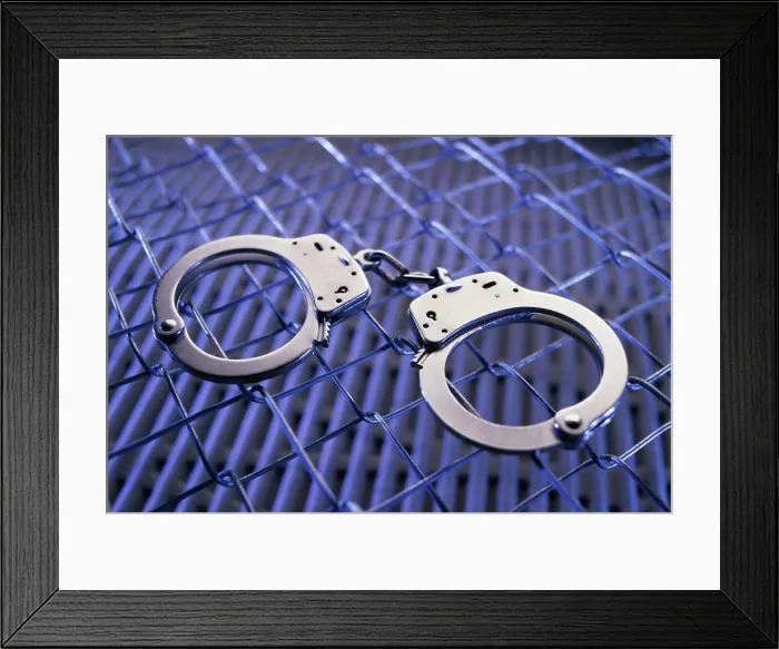 Framed Print : Close-up of a pair of handcuffs on a chain-link fence Framed Print : Close-up of a pair of handcuffs on a chain-link fence