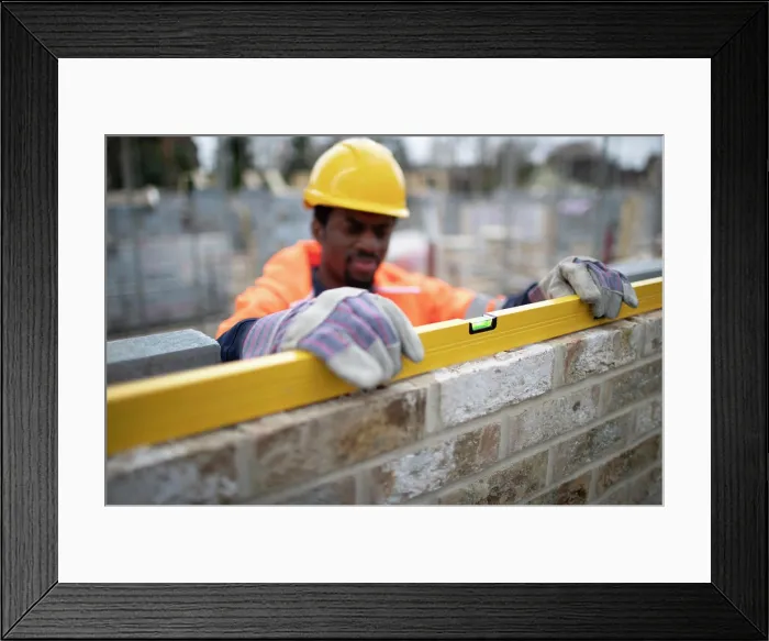 Framed Print : Male construction worker using level tool on brick wall Framed Print : Male construction worker using level tool on brick wall