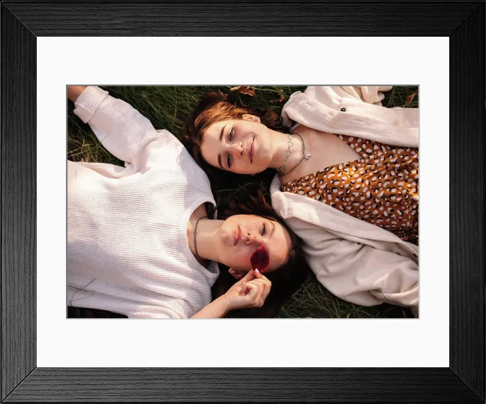 Framed Print : Overhead view of two young women lying on grass Framed Print : Overhead view of two young women lying on grass