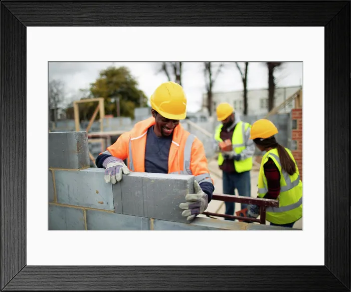 Framed Print : Male construction site laying brick at construction site Framed Print : Male construction site laying brick at construction site