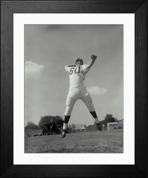 Framed Print : Low angle view of a football player throwing a football