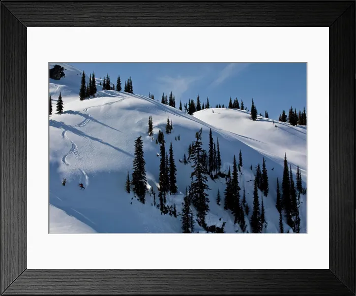 Framed Print : A male skier earns his turns and skis fresh powder while ski touring