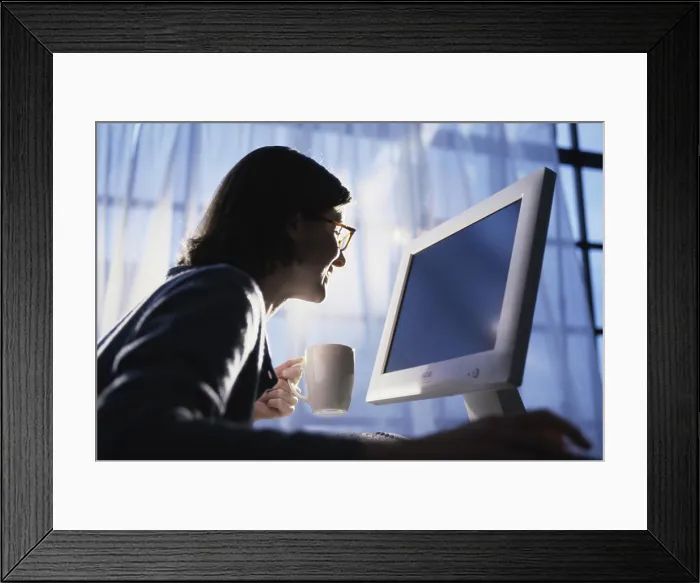 Framed Print : Side profile of a young woman using a computer