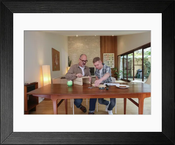 Framed Print : Father helping adult son to put together wooden box Framed Print : Father helping adult son to put together wooden box