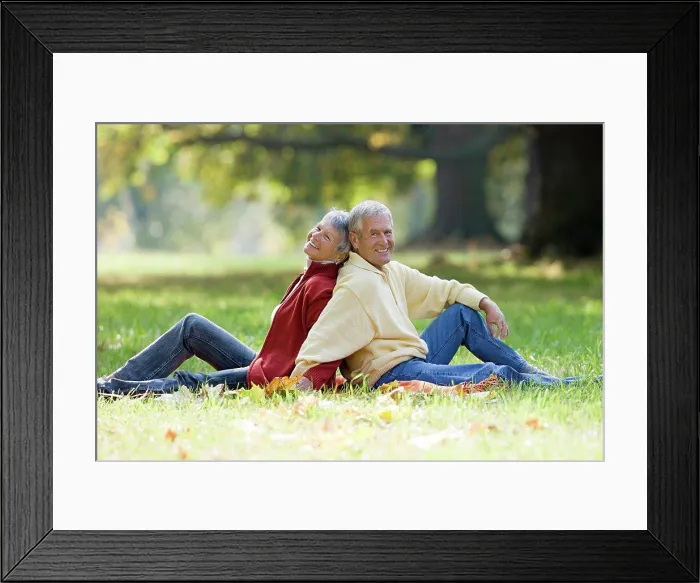 Framed Print : Senior couple sitting back to back in a park Framed Print : Senior couple sitting back to back in a park