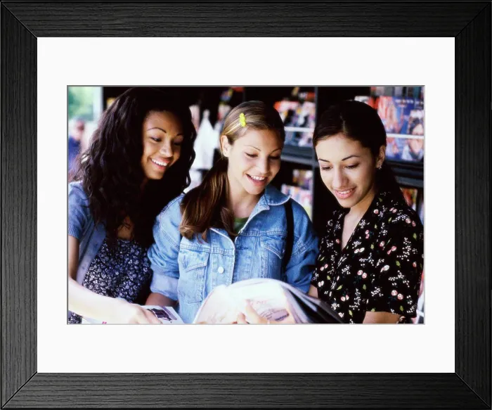 Framed Print : Three teenage girls reading a magazine