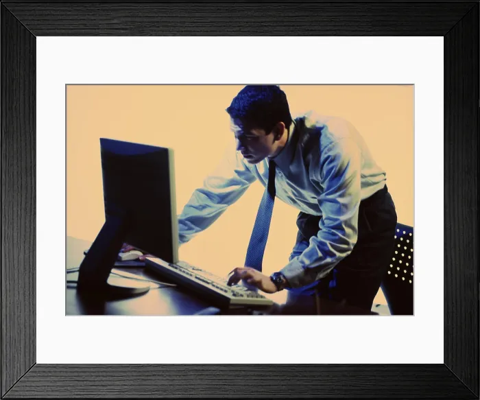 Framed Print : Side profile of a businessman using a computer Framed Print : Side profile of a businessman using a computer