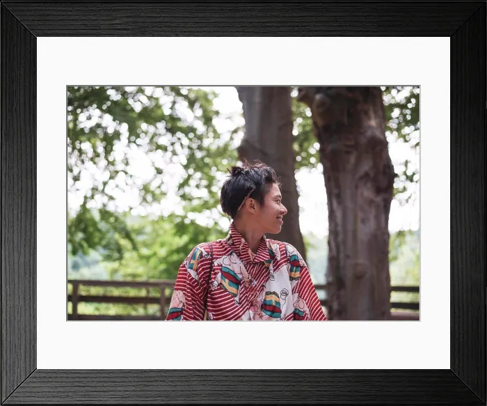 Framed Print : Profile of smiling non-binary adult in colourful shirt in forrest Framed Print : Profile of smiling non-binary adult in colourful shirt in forrest