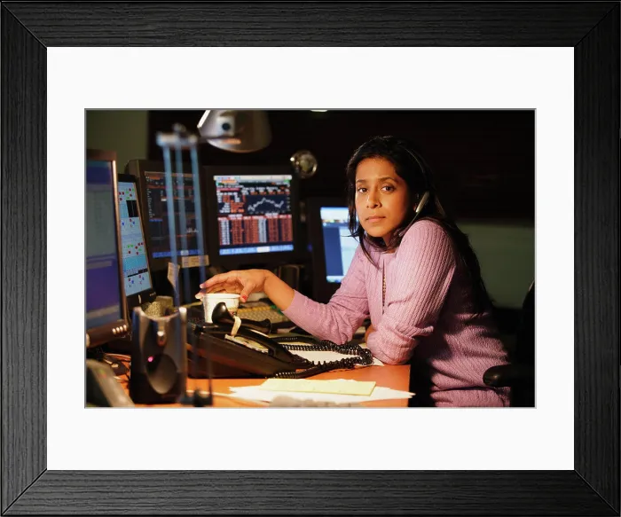 Framed Print : Middle aged businesswoman posing for the camera at her desk Framed Print : Middle aged businesswoman posing for the camera at her desk