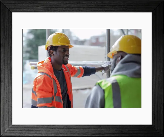 Framed Print : Male construction workers talking at construction site Framed Print : Male construction workers talking at construction site