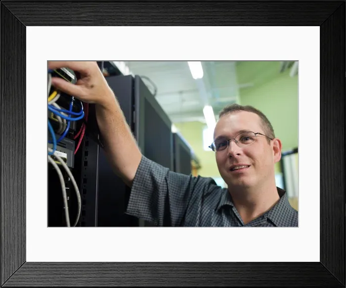 Framed Print : Close-up of a technician checking cables of a computer network Framed Print : Close-up of a technician checking cables of a computer network