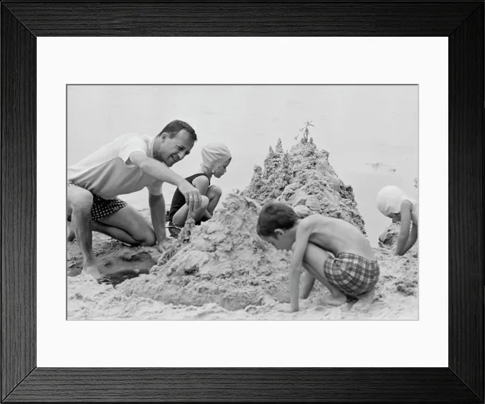 Framed Print : Father with three children building sand castle on beach Framed Print : Father with three children building sand castle on beach