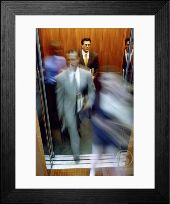 Framed Print : Businessman and a businesswoman exiting an elevator Framed Print : Businessman and a businesswoman exiting an elevator