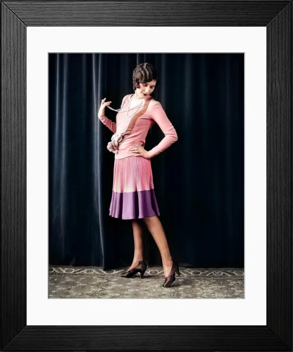 Framed Print : 1920s FLAPPER WOMAN POSING HAND ON HIP HOLDING STRING OF PEARLS STRETCHING LEG CHECKING HOSIERY SEAMS
