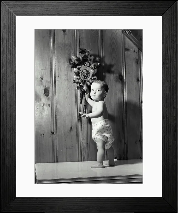 Framed Print : Portrait of a baby boy standing near a cuckoo clock Framed Print : Portrait of a baby boy standing near a cuckoo clock