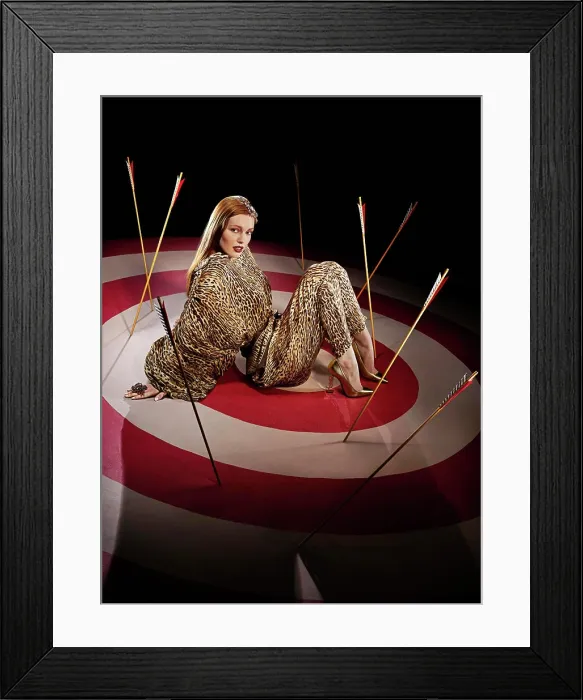 Framed Print : Full length portrait of a woman on large hand painted Bulls-eye target with arrows Framed Print : Full length portrait of a woman on large hand painted Bulls-eye target with arrows