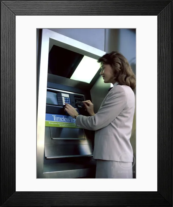 Framed Print : Businesswoman operating an ATM Framed Print : Businesswoman operating an ATM