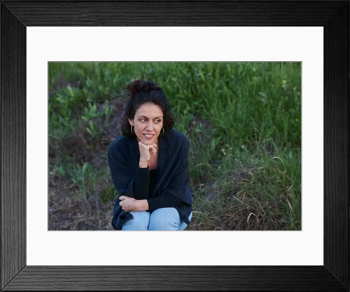 Framed Print : Portrait of a woman sitting in the field at sunset Framed Print : Portrait of a woman sitting in the field at sunset