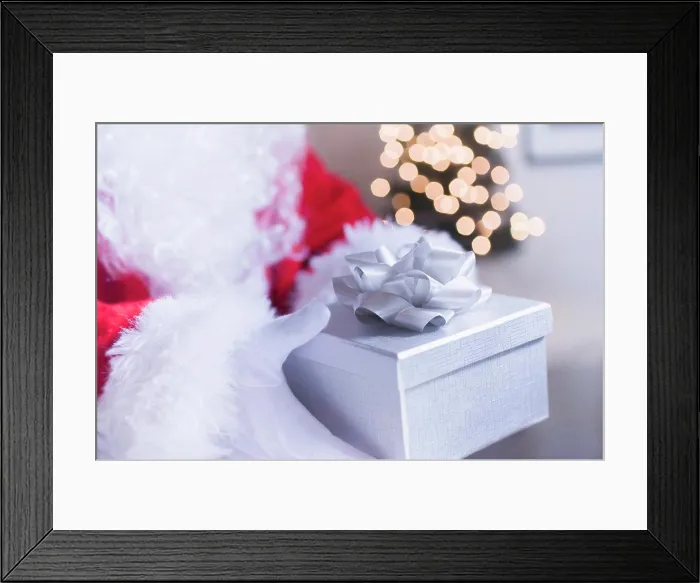 Framed Print : Santa Claus Hand Holding Christmas Gift, Close-up Framed Print : Santa Claus Hand Holding Christmas Gift, Close-up