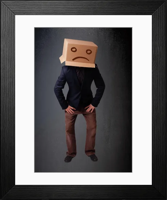 Framed Print : Junger Mann mit einem braunen Karton auf seinem Kopf mit traurigem Gesicht Young man standing with a brown cardboard