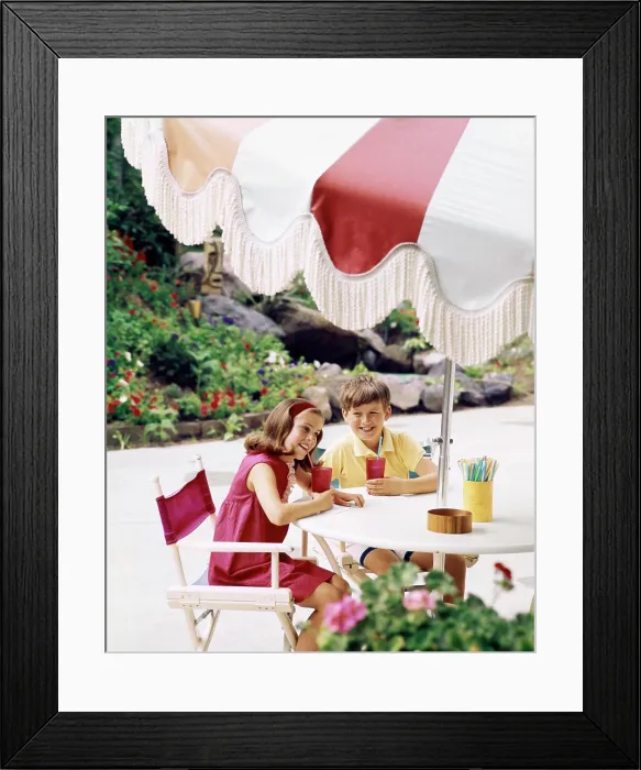 Framed Print : 1970s BOY AND GIRL WITH COOL DRINKS AT TABLE WITH LARGE UMBRELLA OUTDOORS Framed Print : 1970s BOY AND GIRL WITH COOL DRINKS AT TABLE WITH LARGE UMBRELLA OUTDOORS