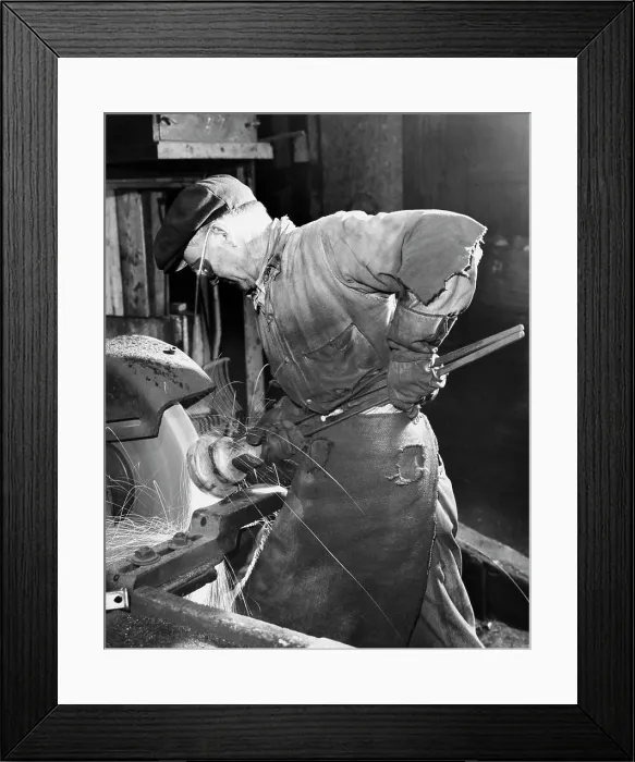 Framed Print : Side profile of a senior man working on a machine in a factory Framed Print : Side profile of a senior man working on a machine in a factory
