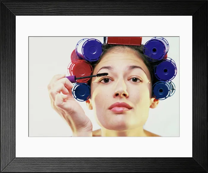Framed Print : Portrait of a young woman applying mascara Framed Print : Portrait of a young woman applying mascara