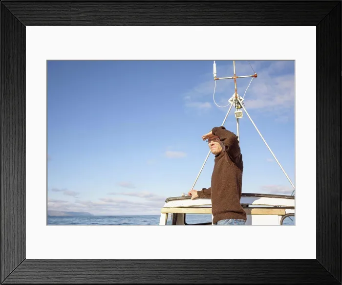 Framed Print : Man on fishing boat in sea