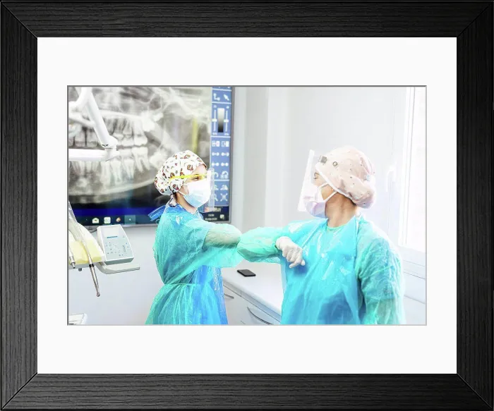 Framed Print : Dentist and assistant in protective workwear greeting with elbow at office Framed Print : Dentist and assistant in protective workwear greeting with elbow at office