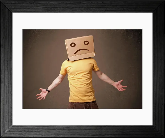 Framed Print : Junger Mann mit einem braunen Karton auf seinem Kopf mit traurigem Gesicht Young man standing with a brown cardboard Framed Print : Junger Mann mit einem braunen Karton auf seinem Kopf mit traurigem Gesicht Young man standing with a brown cardboard