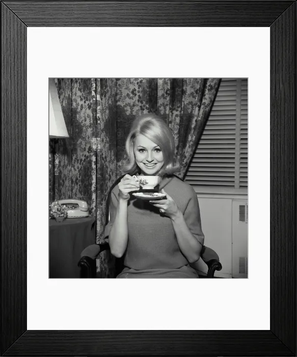 Framed Print : Portrait of a young woman smiling and holding a tea cup Framed Print : Portrait of a young woman smiling and holding a tea cup
