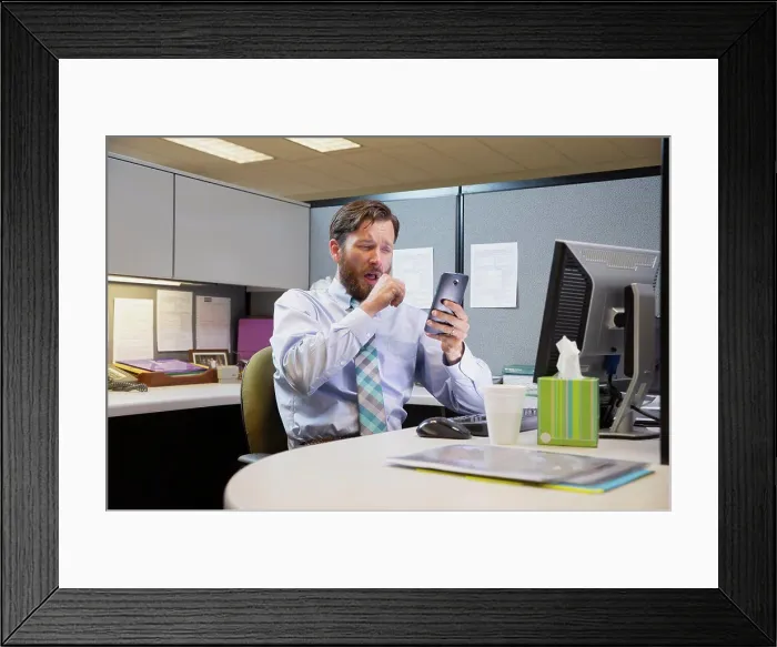 Framed Print : coughing young Caucasian man working in cubicle at office Framed Print : coughing young Caucasian man working in cubicle at office