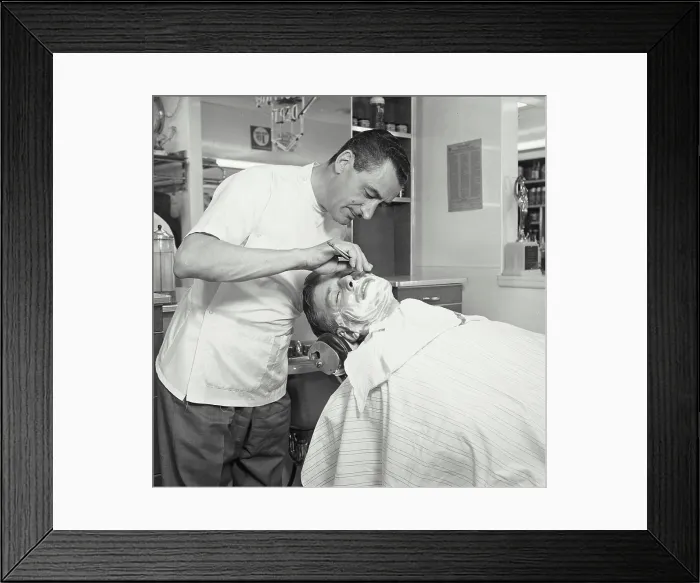 Framed Print : Side profile of a barber shaving a mid adult man in a barbershop Framed Print : Side profile of a barber shaving a mid adult man in a barbershop