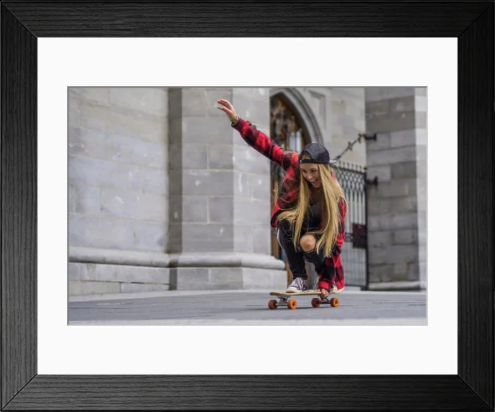 Framed Print : Female skateboarder balancing herself on skateboard rolling arou Framed Print : Female skateboarder balancing herself on skateboard rolling arou