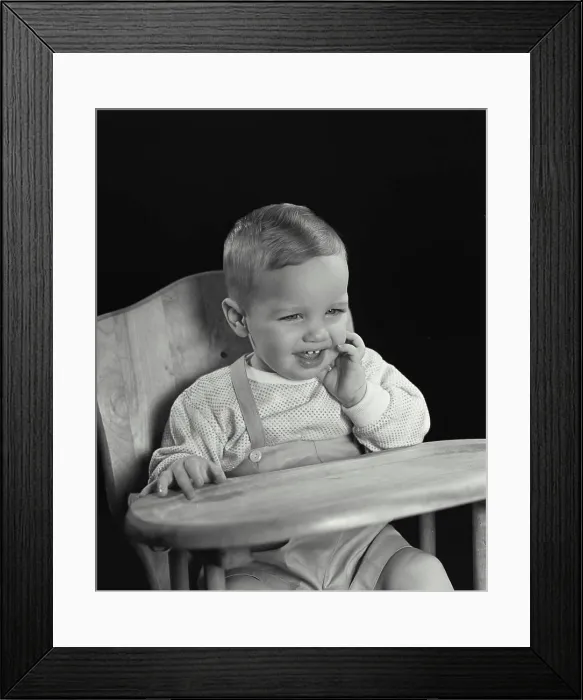 Framed Print : Close-up of a baby sitting in a high chair and smiling Framed Print : Close-up of a baby sitting in a high chair and smiling