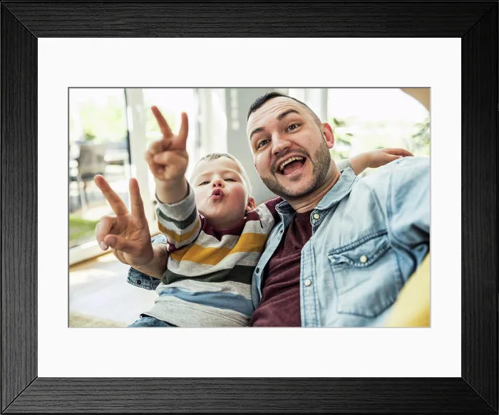 Framed Print : Happy father and son gesturing peace sign in living room at home Framed Print : Happy father and son gesturing peace sign in living room at home