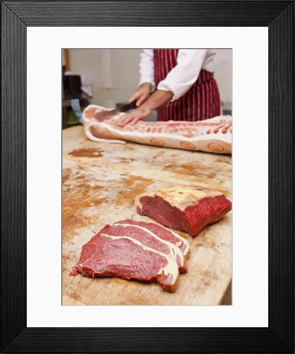 Framed Print : Butcher carving meat in shop Framed Print : Butcher carving meat in shop