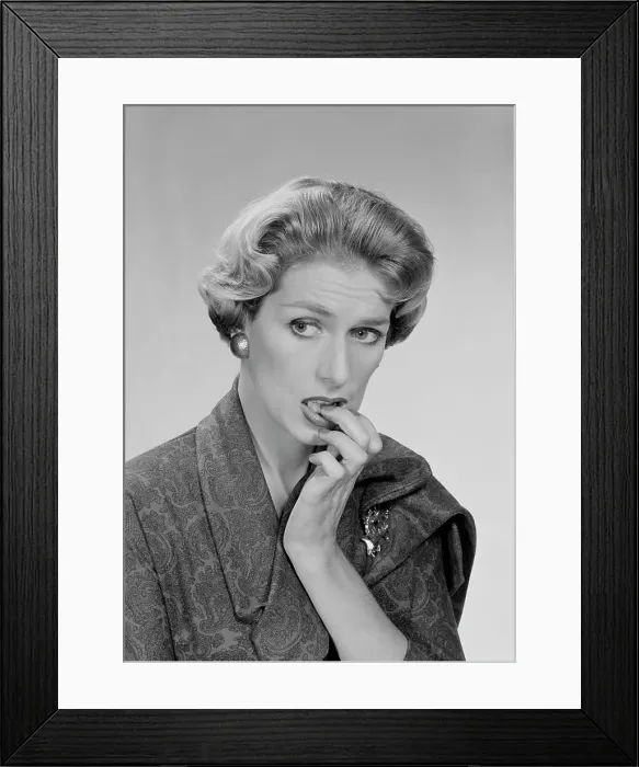 Framed Print : Mid adult woman biting her nails and looking away, studio shot