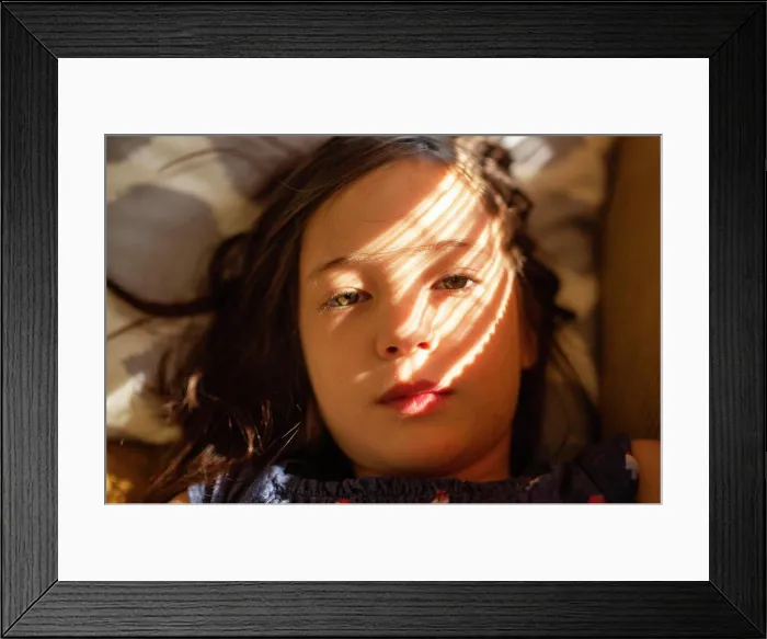 Framed Print : close-up portrait of beautiful girl laying in dappled window light