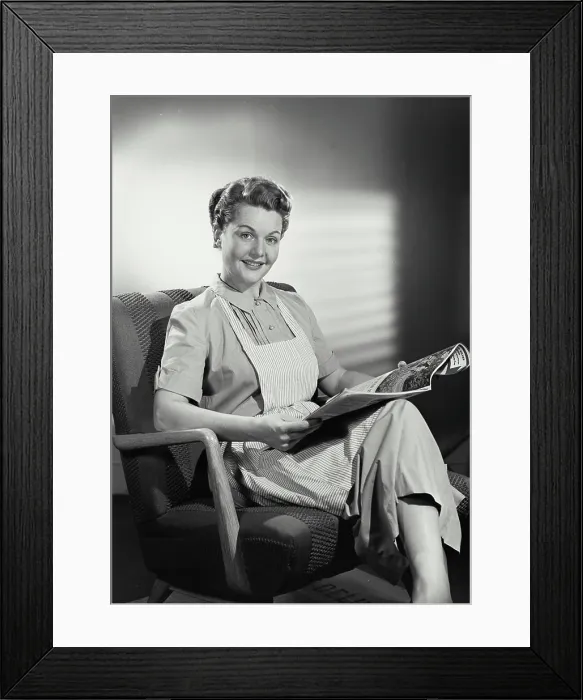 Framed Print : Vintage photograph. Portrait of woman in striped apron sitting and reading newspaper Framed Print : Vintage photograph. Portrait of woman in striped apron sitting and reading newspaper
