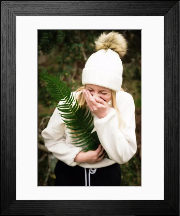 Framed Print : Teen Girl in Winter Hat Holding Green Fern While Laughing Framed Print : Teen Girl in Winter Hat Holding Green Fern While Laughing