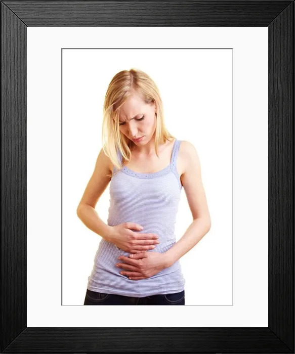 Framed Print : Young blonde woman with stomach ache holding her belly Framed Print : Young blonde woman with stomach ache holding her belly