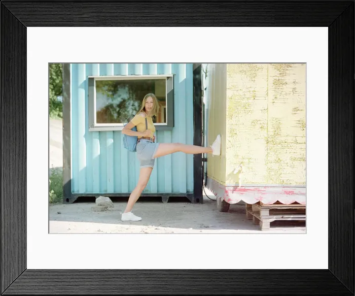 Framed Print : Woman with backpack standing near old mobile homes Framed Print : Woman with backpack standing near old mobile homes