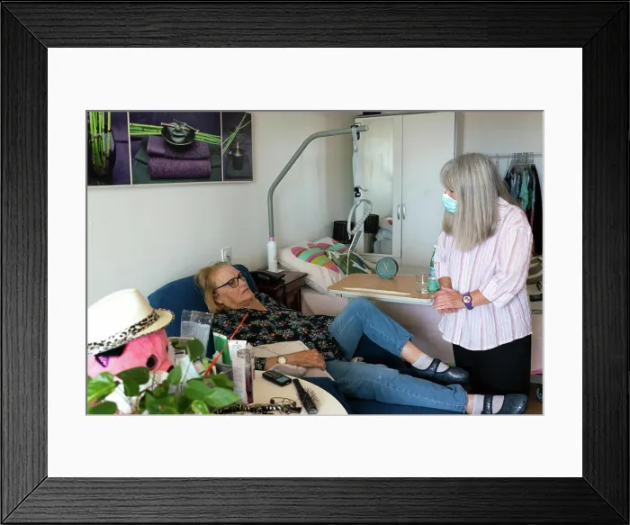 Framed Print : Caregiver in a retirement home looking after a septuagenarian with Parkinson's to do her cooking and cleaning Framed Print : Caregiver in a retirement home looking after a septuagenarian with Parkinson's to do her cooking and cleaning
